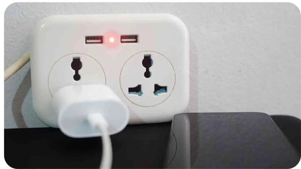 an electrical outlet with a cell phone plugged into it